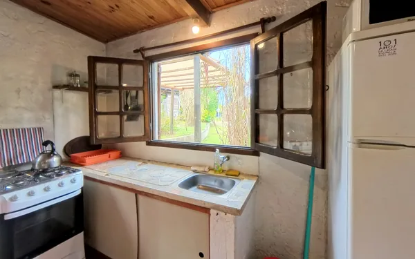 Cocina con horno, heladera y ventana al jardín